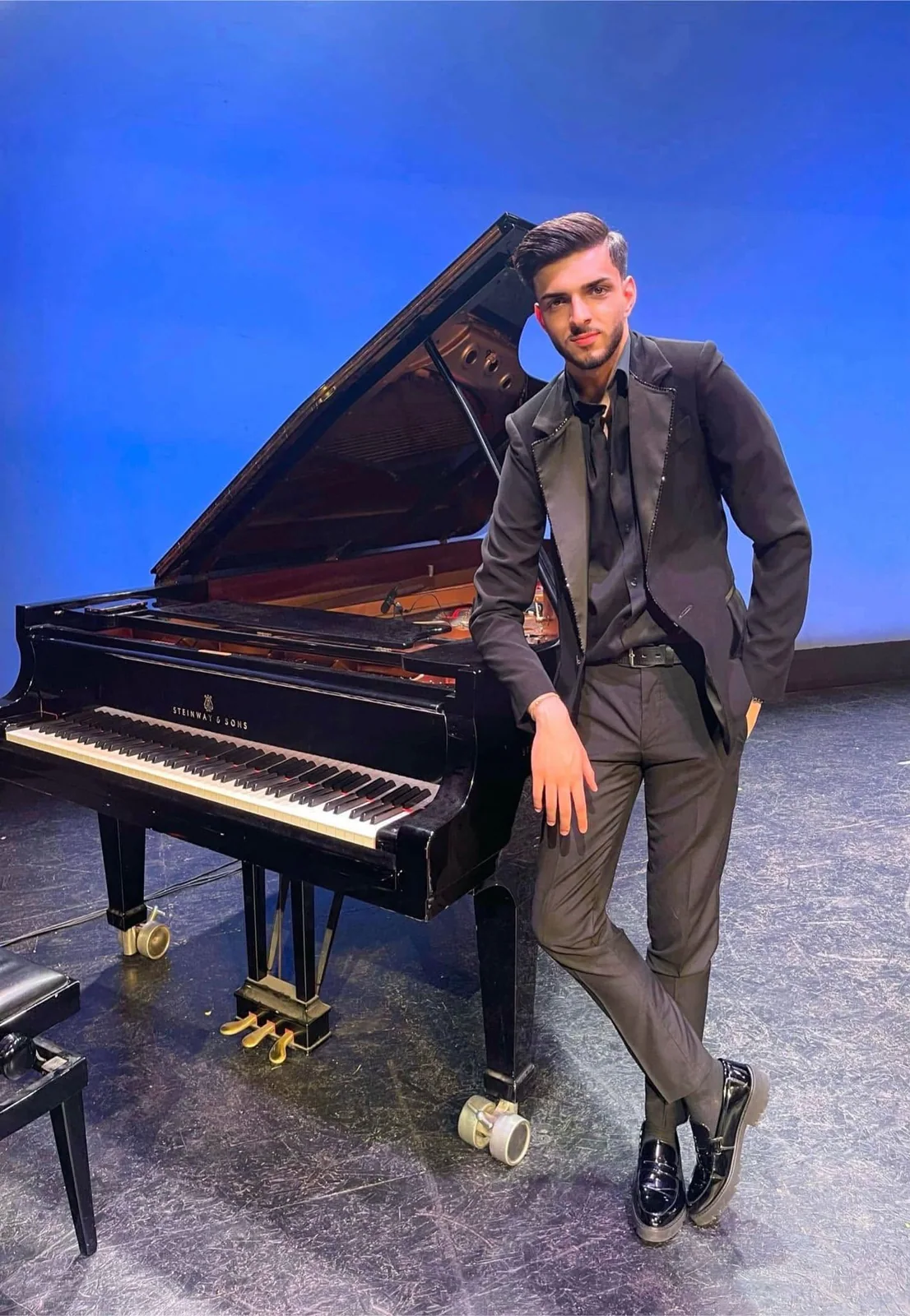 Albert Gugulan lângă un pian Steinway.